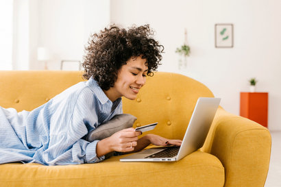 woman using her laptop and her credit card to shop online