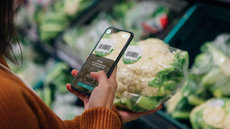 img-int-woman-hand-holding-a-mobile-phone-to-scan-product-code-in-grocery-store
